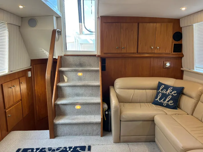Musketeer Yacht Photos Pics Interior of 2000 Carver 406 Aft Cabin Motor Yacht with stairs, sofa, and wooden cabinets.