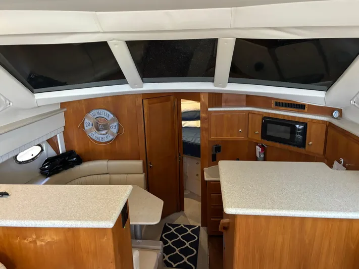 Musketeer Yacht Photos Pics Interior of 2000 Carver 406 Aft Cabin Motor Yacht with kitchen and seating area.