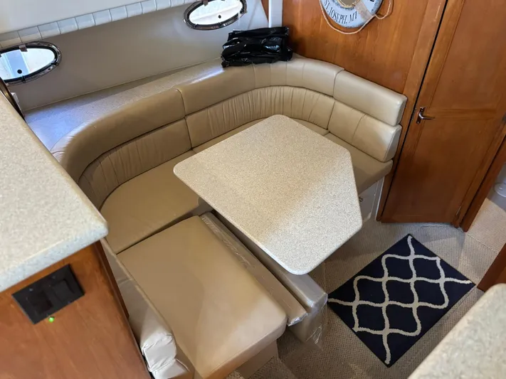 Musketeer Yacht Photos Pics 2000 Carver 406 Aft Cabin Motor Yacht interior with beige seating and table.
