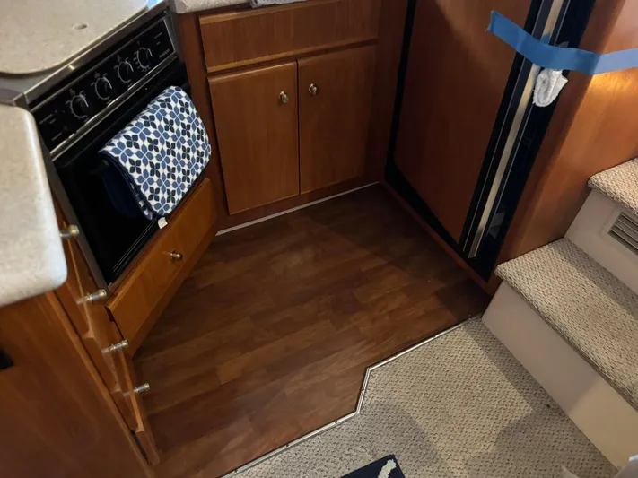Musketeer Yacht Photos Pics Interior of 2000 Carver 406 Aft Cabin Motor Yacht kitchen with wood cabinets and stairs.
