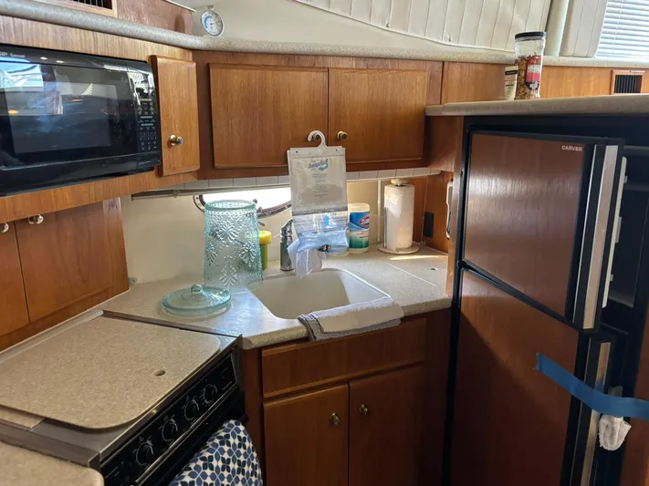 Musketeer Yacht Photos Pics Kitchen area of 2000 Carver 406 Aft Cabin Motor Yacht with wooden cabinets and appliances.