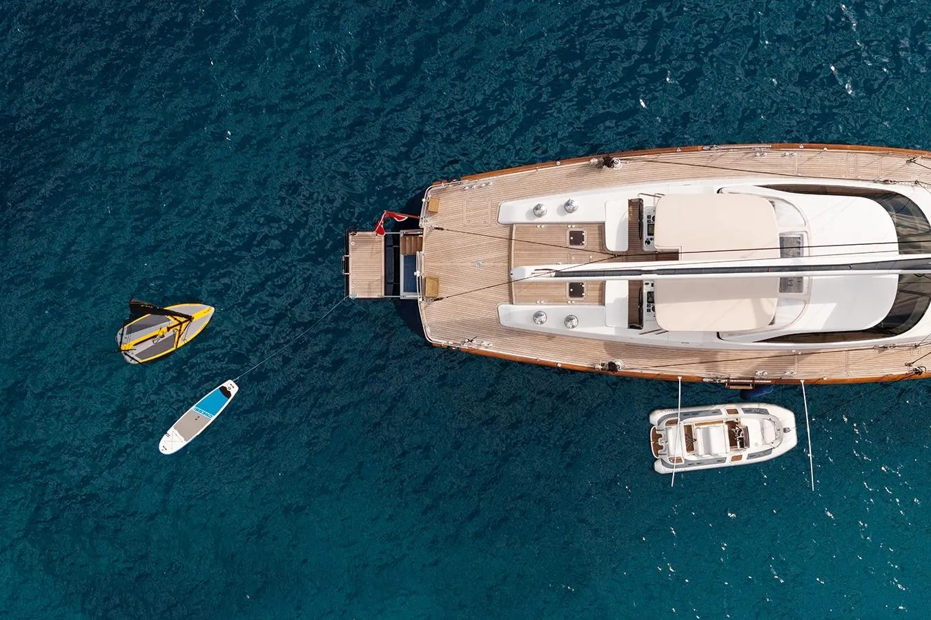 Aerial view of a 2009 Steve Ward & Co custom yacht with paddleboards on blue water.
