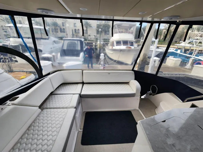 Foxyot Yacht Photos Pics 2022 Regal 38 Grande Coupe interior with luxurious seating and marina view.