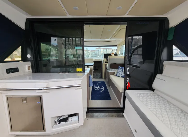 Foxyot Yacht Photos Pics 2022 Regal 38 Grande Coupe interior with modern seating and kitchenette.