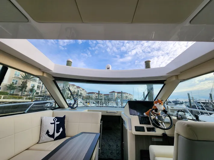Foxyot Yacht Photos Pics Interior view of 2022 Regal 38 Grande Coupe yacht with marina backdrop.