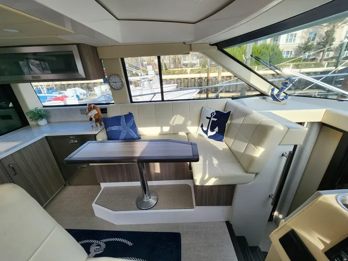 Foxyot Yacht Photos Pics Luxurious interior of 2022 Regal 38 Grande Coupe yacht with elegant seating and nautical decor.