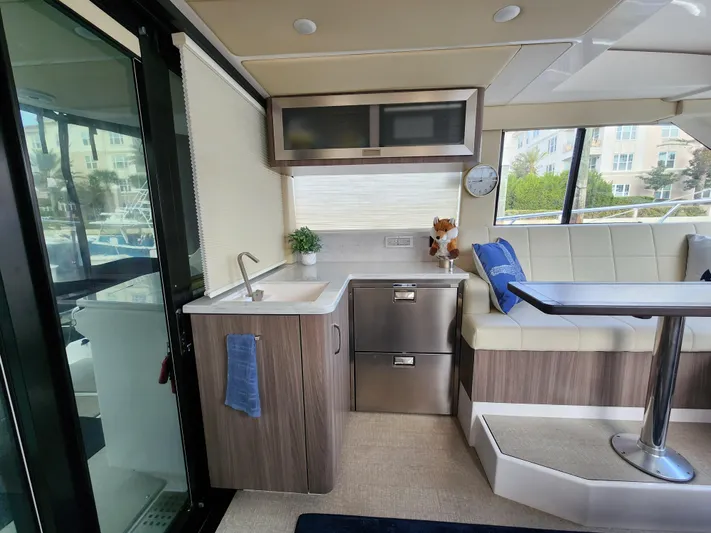 Foxyot Yacht Photos Pics Interior of 2022 Regal 38 Grande Coupe yacht with modern kitchen and seating area.