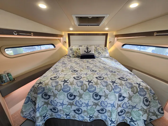 Foxyot Yacht Photos Pics Luxurious bedroom interior of 2022 Regal 38 Grande Coupe yacht with nautical-themed bedding.