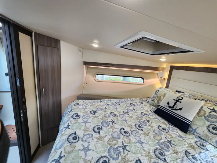 Foxyot Yacht Photos Pics Interior of 2022 Regal 38 Grande Coupe bedroom with nautical-themed bedding.
