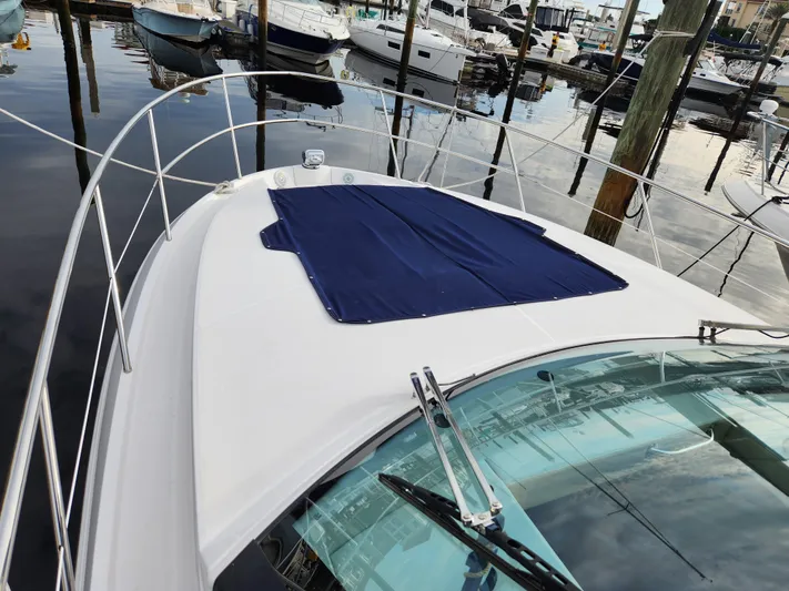 Foxyot Yacht Photos Pics 2022 Regal 38 Grande Coupe yacht docked at marina, featuring sleek design and blue cover.