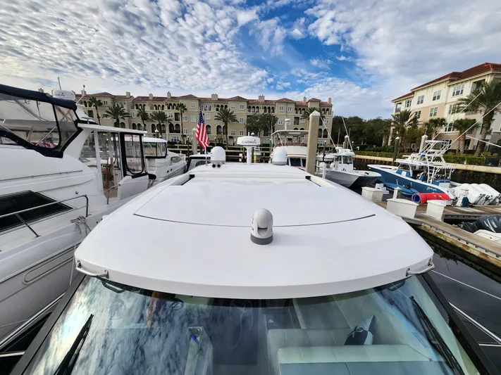 Foxyot Yacht Photos Pics 2022 Regal 38 Grande Coupe docked at marina with luxury buildings in background.