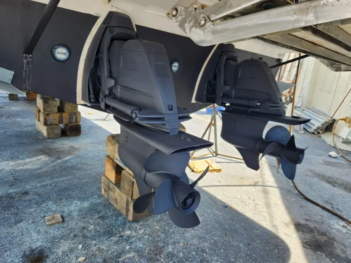 Foxyot Yacht Photos Pics 2022 Regal 38 Grande Coupe boat propellers on dry dock, showcasing dual outboard motors.
