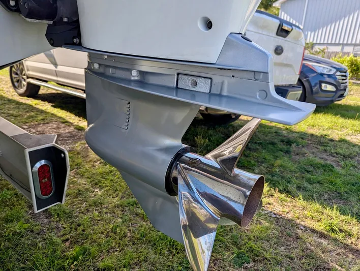  Yacht Photos Pics 2020 Yellowfin 39 Offshore boat propeller and motor detail, parked on grass.