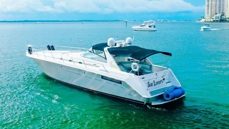  Yacht Photos Pics 1994 Sea Ray 500 Sundancer yacht on clear blue water, with city skyline in background.