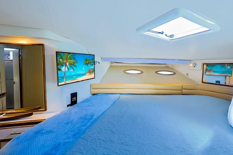  Yacht Photos Pics Luxurious 1994 Sea Ray 500 Sundancer cabin with cozy bed and scenic TV display.