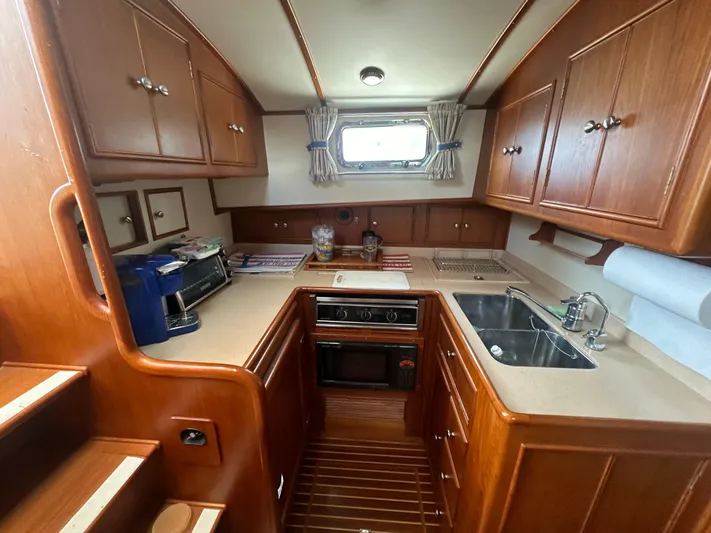 Vivacious Yacht Photos Pics 2002 Grand Banks Eastbay 43 yacht kitchen with wood cabinetry and modern appliances.