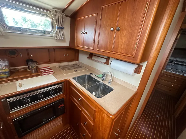Vivacious Yacht Photos Pics Luxurious 2002 Grand Banks Eastbay 43 yacht kitchen with wood cabinetry and modern amenities.