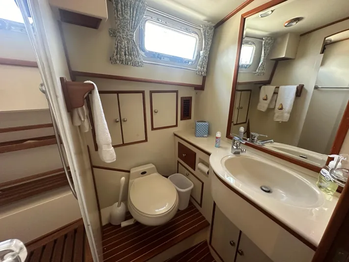 Vivacious Yacht Photos Pics Luxurious bathroom in 2002 Grand Banks Eastbay 43 yacht with wood accents and modern amenities.