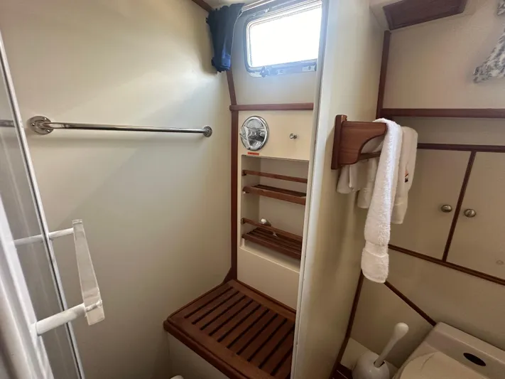 Vivacious Yacht Photos Pics Bathroom interior of 2002 Grand Banks Eastbay 43 yacht, featuring wooden accents and towel rack.