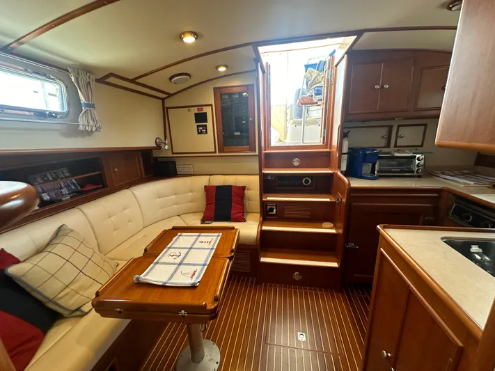 Vivacious Yacht Photos Pics Luxurious 2002 Grand Banks Eastbay 43 yacht interior with cozy seating and wooden cabinetry.