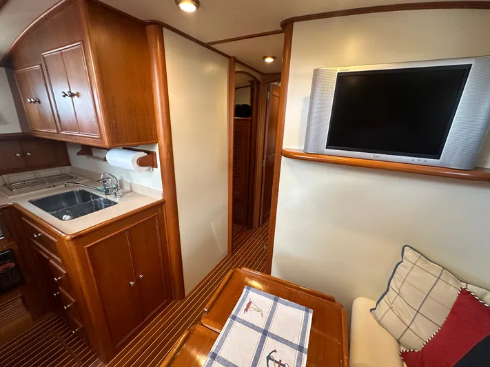 Vivacious Yacht Photos Pics Interior of 2002 Grand Banks Eastbay 43 yacht with kitchen, TV, and seating area.