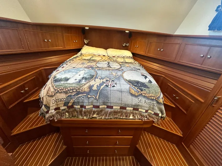 Vivacious Yacht Photos Pics Luxurious 2002 Grand Banks Eastbay 43 cabin with nautical-themed bedding and rich wood cabinetry.