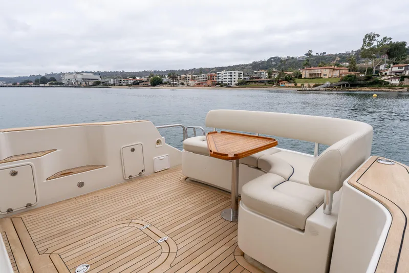 Zissou Yacht Photos Pics 2006 Chris-Craft Roamer 40 yacht deck with seating and table, overlooking coastal scenery.