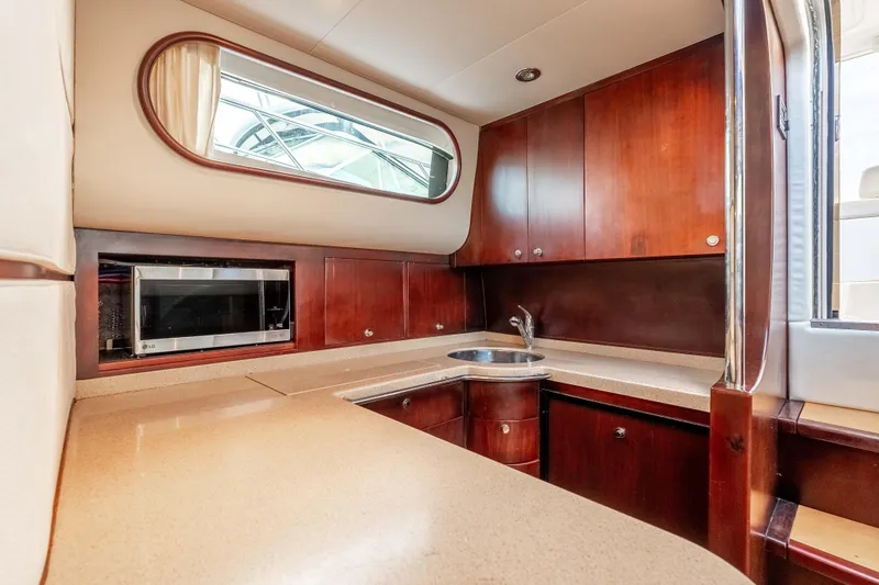 Zissou Yacht Photos Pics Luxurious 2006 Chris-Craft Roamer 40 yacht kitchen with wood cabinetry and modern appliances.