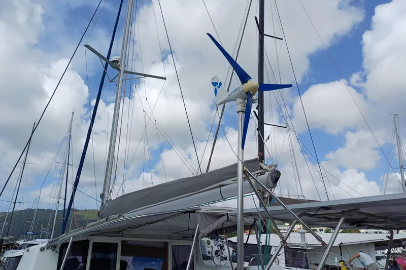  Yacht Photos Pics Fountaine Pajot Mahe 36 catamaran with wind turbine, 2007 model, docked under cloudy sky.