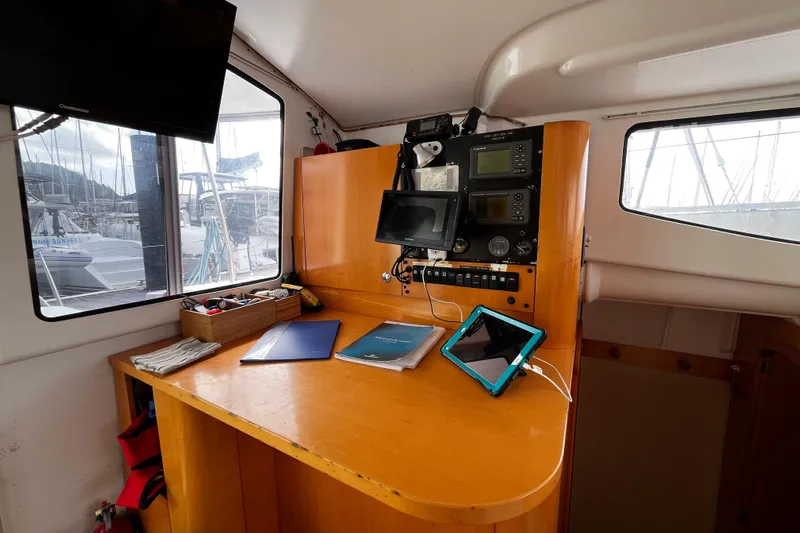  Yacht Photos Pics Navigation station inside 2007 Fountaine Pajot Mahe 36 catamaran with electronic equipment and charts.