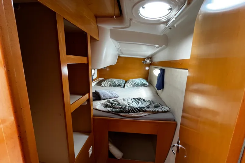  Yacht Photos Pics Cozy cabin interior of 2007 Fountaine Pajot Mahe 36 catamaran with bed and wooden finish.