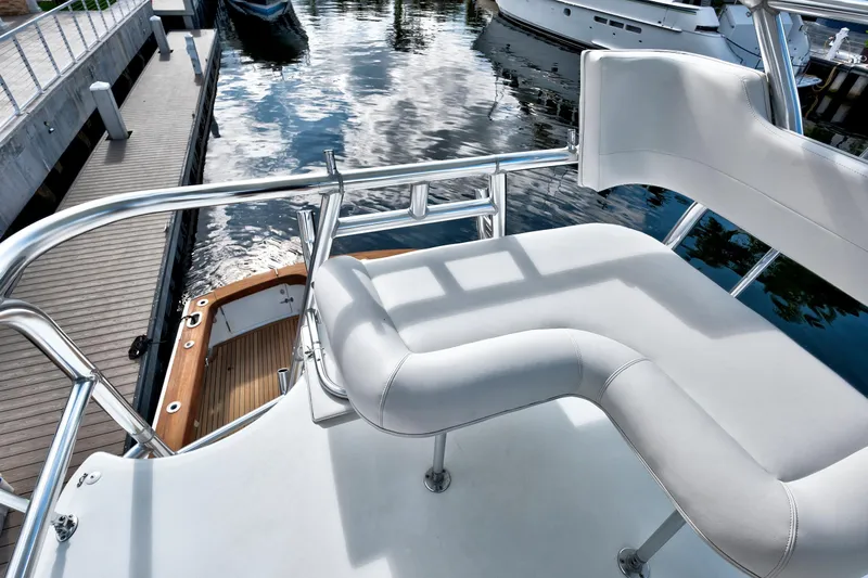 "double Down" Yacht Photos Pics 2014 Release Walkaround boat with white seating and polished railings at a dock.