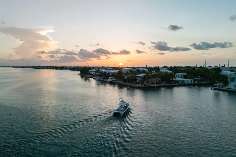  Yacht Photos Pics 2023 Front Runner 36 Center Console boat cruising at sunset on a serene waterway.