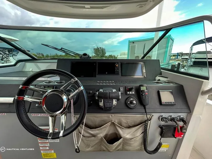  Yacht Photos Pics 2018 Axopar 37 Sun Top helm with steering wheel, navigation screens, and control panel.