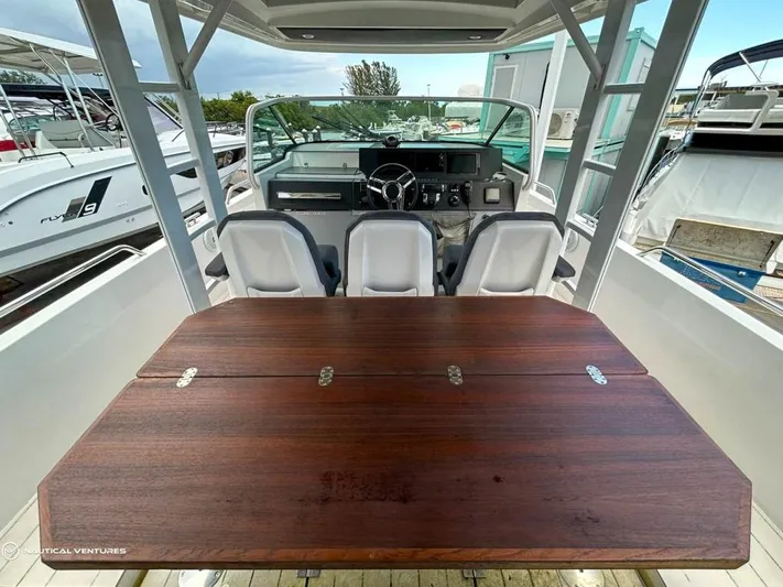  Yacht Photos Pics 2018 Axopar 37 Sun Top boat interior with wooden table and helm station.