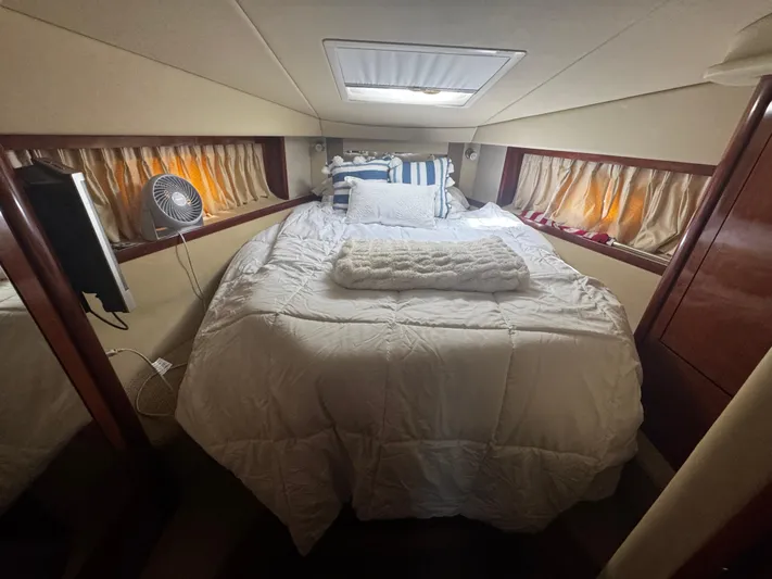  Yacht Photos Pics Cozy bedroom interior of 2006 Sea Ray 380 Sundancer yacht with bed and fan.