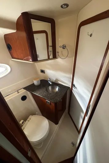  Yacht Photos Pics 2006 Sea Ray 380 Sundancer bathroom with sink, toilet, and wooden cabinetry.