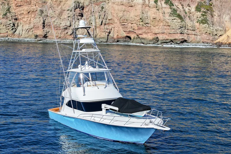 Trouble Maker Yacht Photos Pics 2013 Viking 46 Convertible yacht on calm waters near rocky coastline.