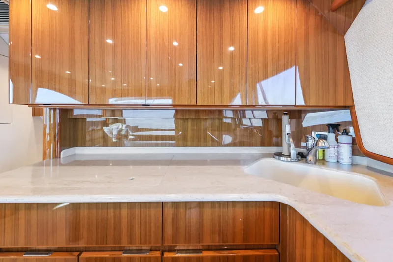 Trouble Maker Yacht Photos Pics Luxurious kitchen interior of 2013 Viking 46 Convertible yacht with wooden cabinets and modern sink.