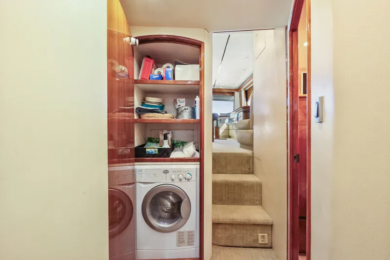 Trouble Maker Yacht Photos Pics Laundry area inside 2013 Viking 46 Convertible yacht, featuring washer and storage shelves.