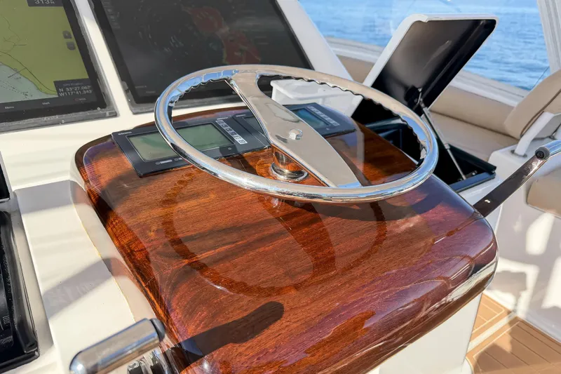 Trouble Maker Yacht Photos Pics Steering wheel of 2013 Viking 46 Convertible yacht with polished wood finish.