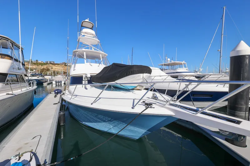Trouble Maker Yacht Photos Pics 2013 Viking 46 Convertible yacht docked in a marina under clear blue skies.