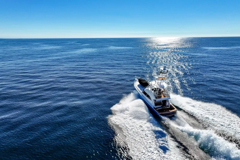 Trouble Maker Yacht Photos Pics 2013 Viking 46 Convertible yacht cruising on open ocean under clear blue sky.