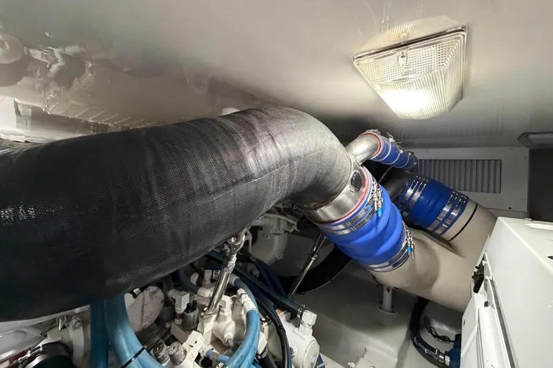 Trouble Maker Yacht Photos Pics Engine room of 2013 Viking 46 Convertible yacht with blue hoses and exhaust system.