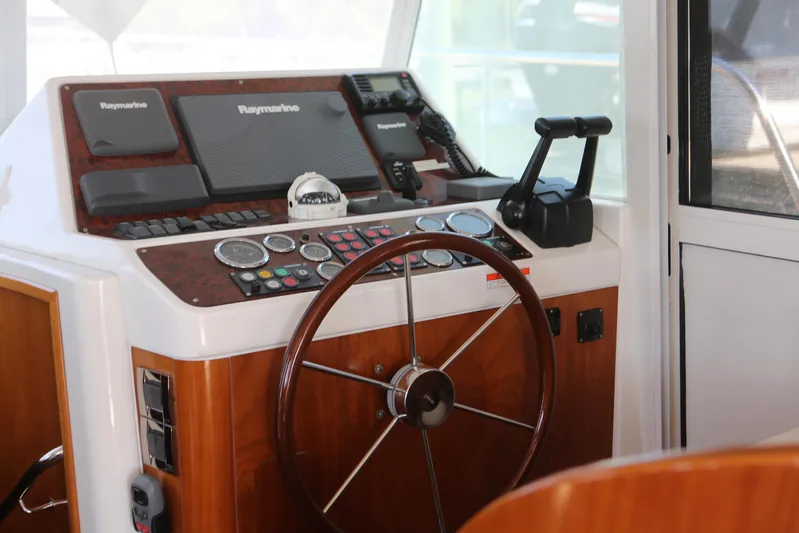 Gracie May Yacht Photos Pics 2007 Beneteau Swift Trawler 42 helm with wooden steering wheel and navigation equipment.