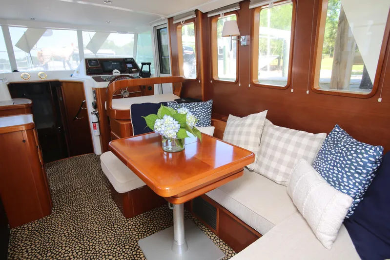 Gracie May Yacht Photos Pics 2007 Beneteau Swift Trawler 42 interior with cozy seating, wooden table, and decorative cushions.