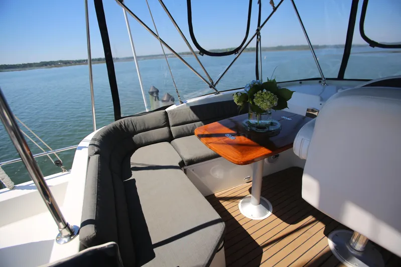Gracie May Yacht Photos Pics 2007 Beneteau Swift Trawler 42 interior with cushioned seating and wooden table, overlooking serene waters.