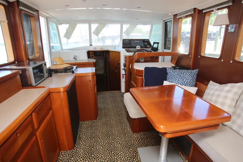Gracie May Yacht Photos Pics Interior of 2007 Beneteau Swift Trawler 42 with wood finishes and seating area.