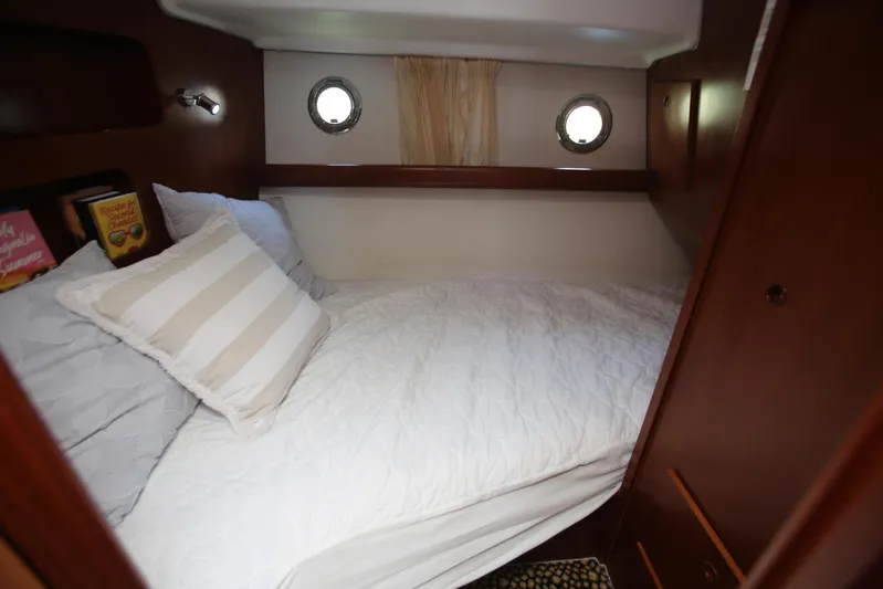 Gracie May Yacht Photos Pics Cozy cabin interior of 2007 Beneteau Swift Trawler 42 with bed and portholes.