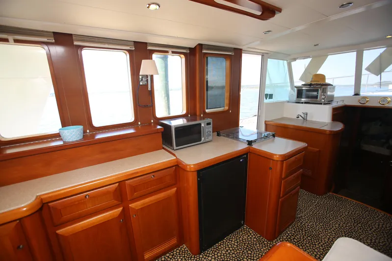 Gracie May Yacht Photos Pics Interior of 2007 Beneteau Swift Trawler 42 with kitchen appliances and wooden cabinetry.